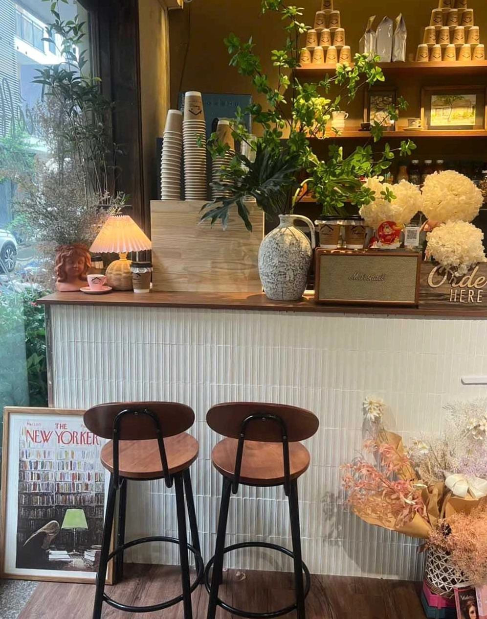 Ảnh chụp chi tiết một tách cà phê nghệ thuật tại Thom Cau, điểm xuyết những vật dụng trang trí nhỏ xinh.