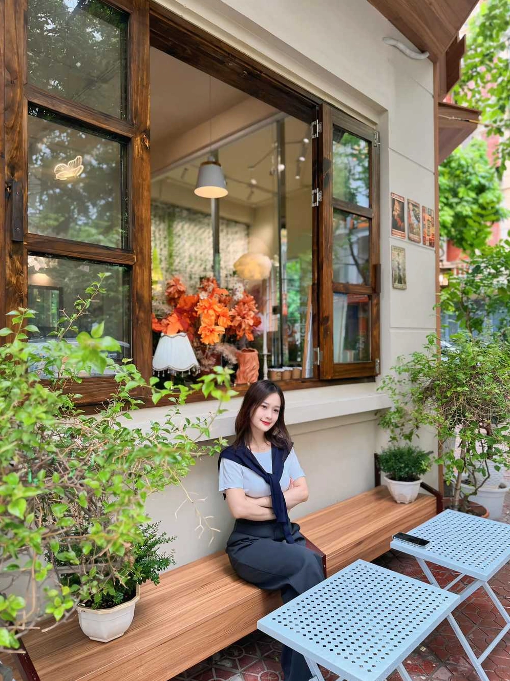 Một góc quán Thom Cau Coffee với không gian xanh mát và ánh sáng dịu nhẹ, tạo cảm giác thư thái.